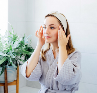 Young woman applying a lash lift kit at home, gently touching her eyelashes, demonstrating the DIY process for eyelash lifting and curling.
